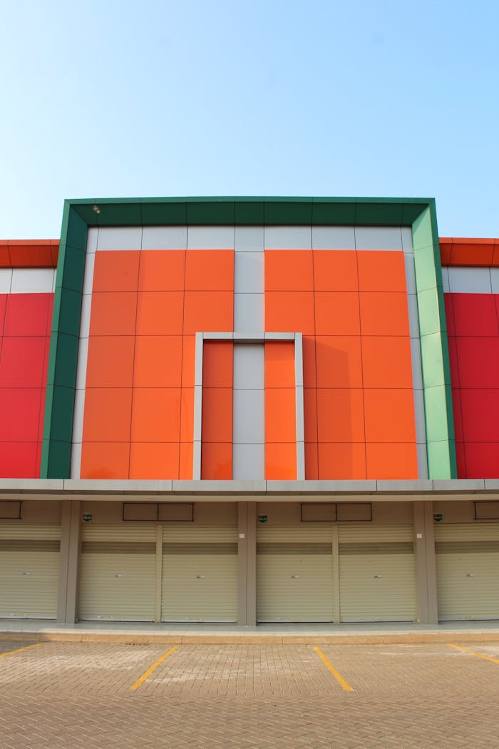 Symmetrical front view of a vibrant building exterior with closed garage doors and colorful panels.